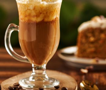 A vertical shot of a mochaccino with whipped cream topping arranged on a wooden surface