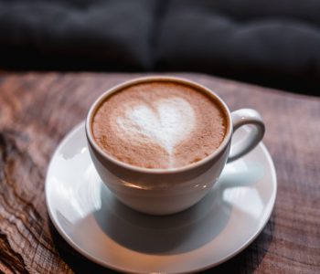 A cup of cappuccino with a heart on it on the table